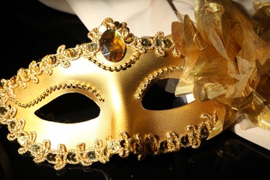 Beautiful golden carnival mask on black background, closeup