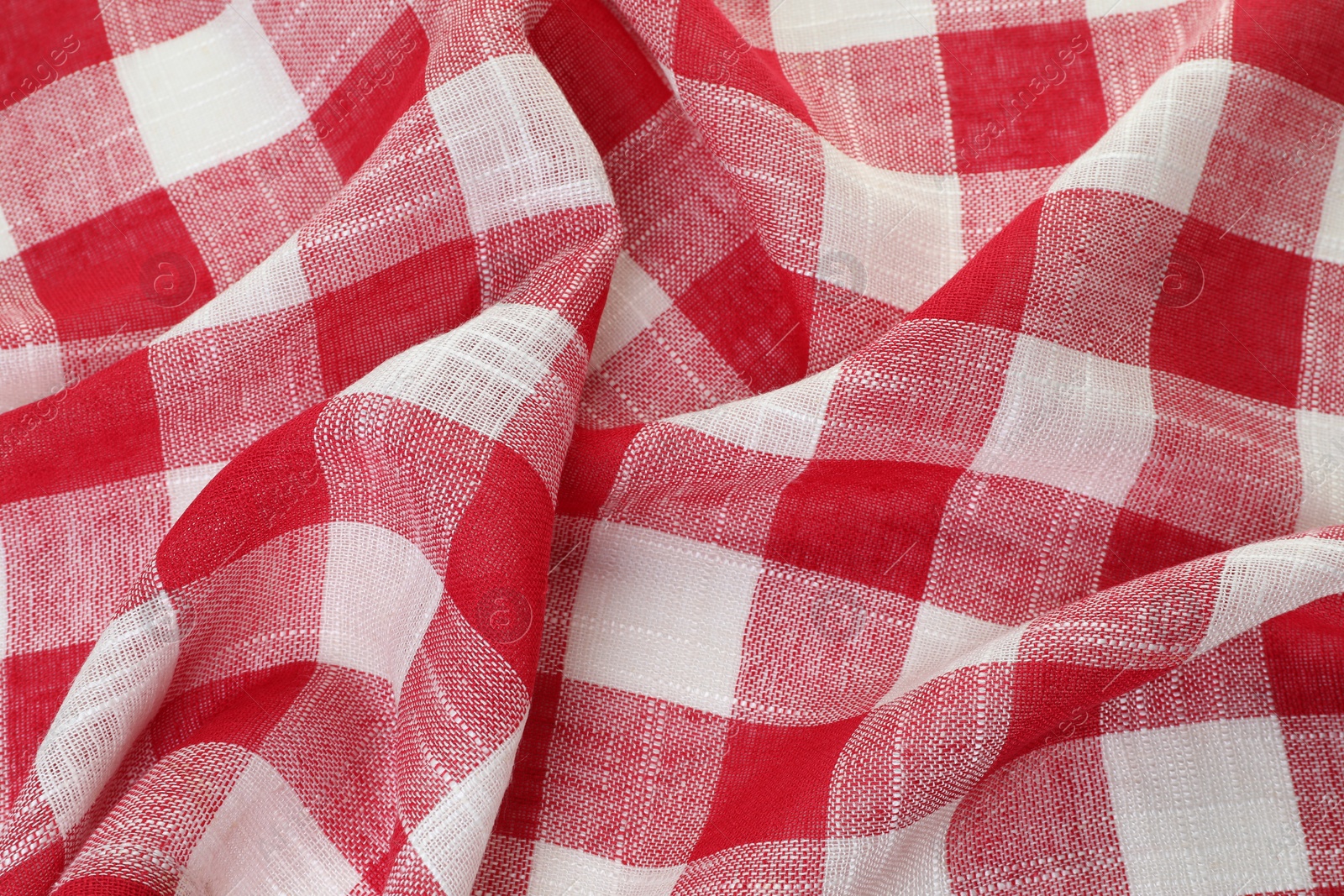 Photo of Crumpled tablecloth with checkered pattern as background, closeup