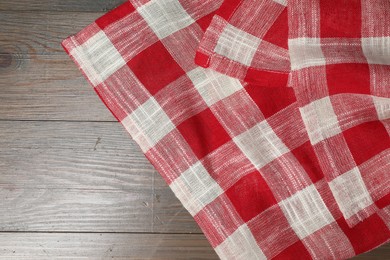 Photo of Crumpled tablecloth with checkered pattern on wooden table, top view