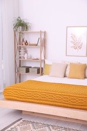 Photo of Large bed near white wall in room. Stylish bedroom interior