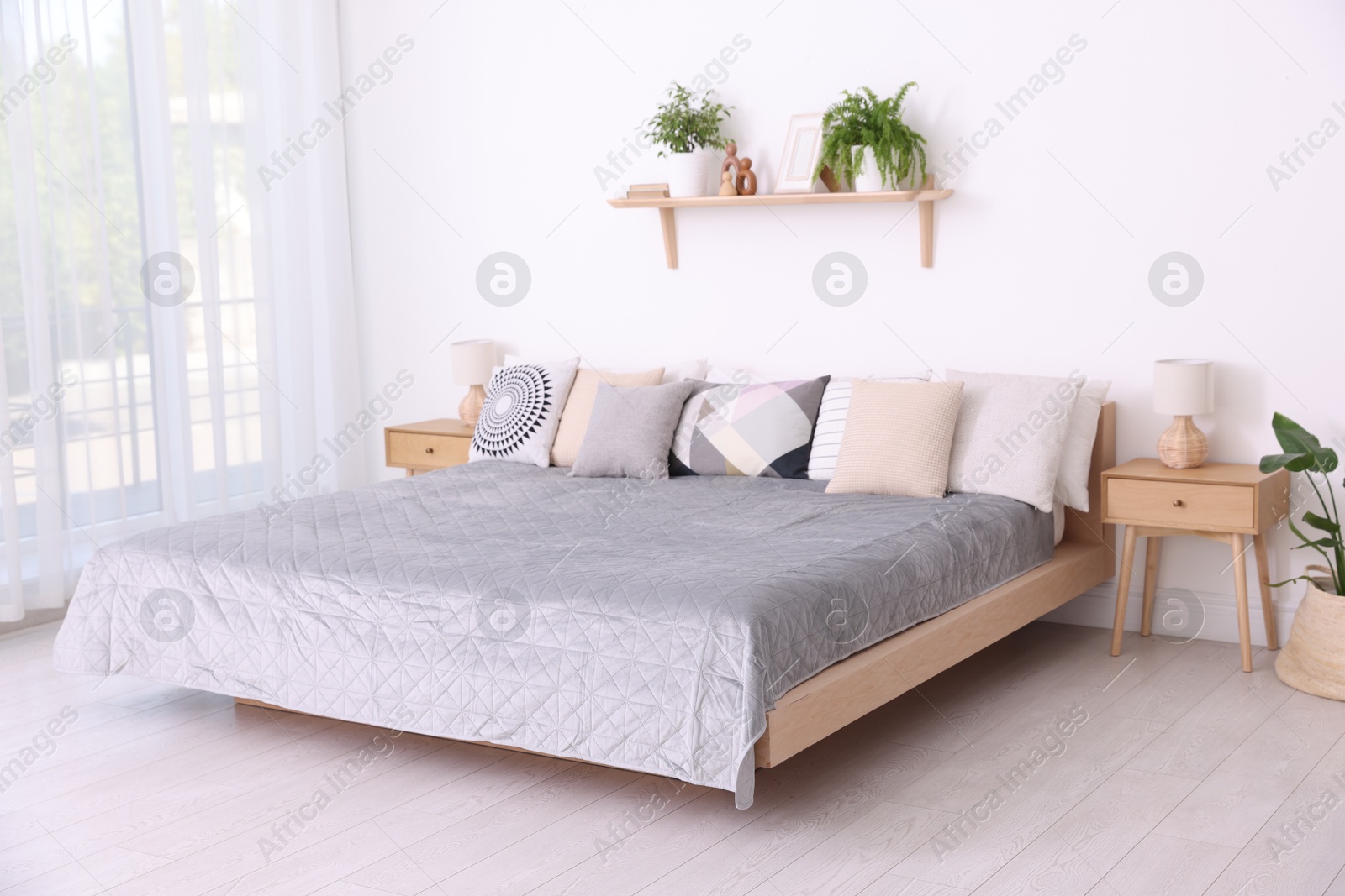 Photo of Large bed near window in room. Stylish bedroom interior