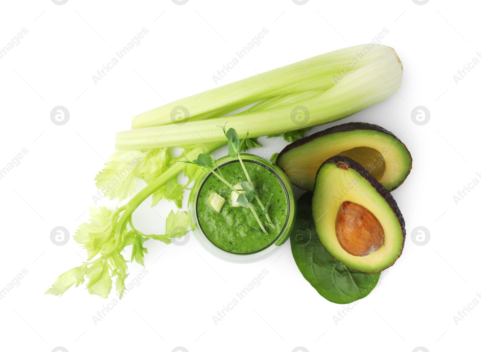 Photo of Tasty green smoothie in glass , avocado and celery isolated on white, top view