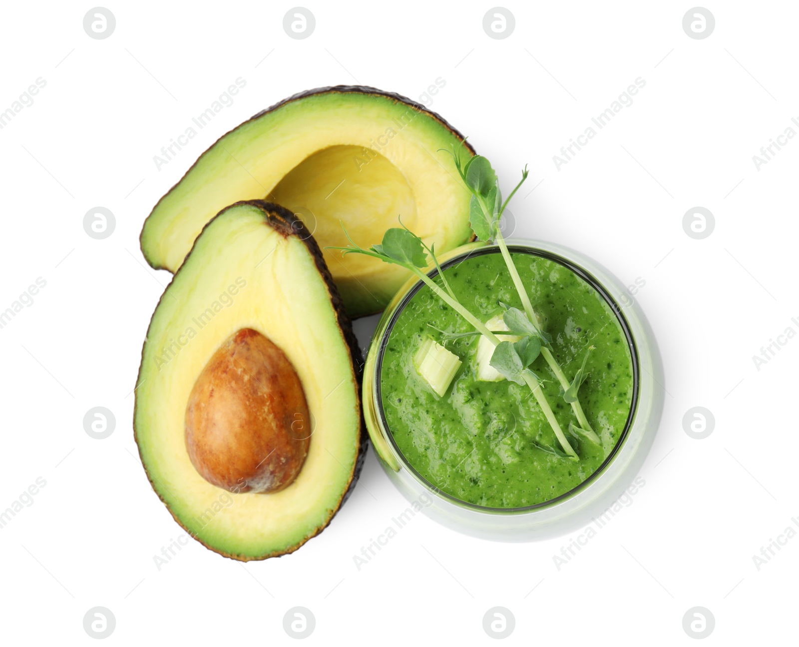 Photo of Tasty green smoothie in glass and avocado isolated on white, top view