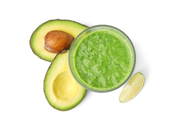 Photo of Tasty green smoothie in glass, avocado and lime isolated on white, top view