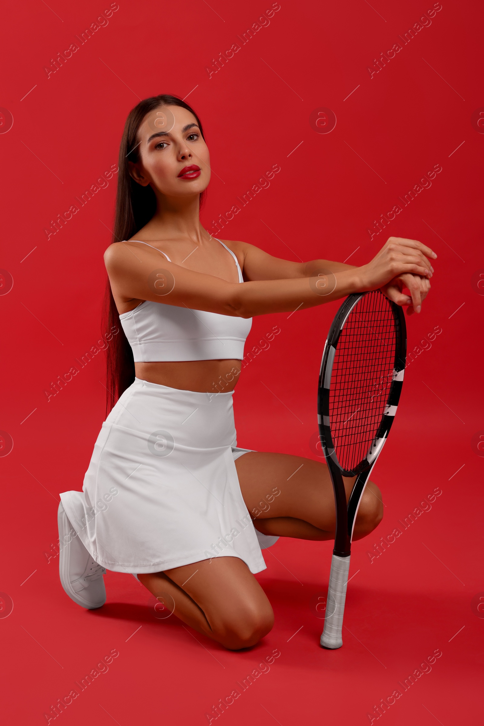 Photo of Beautiful young woman with tennis racket on red background