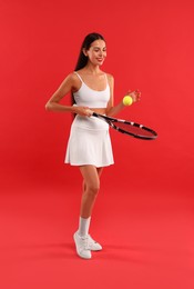 Photo of Happy tennis player with racket and ball on red background