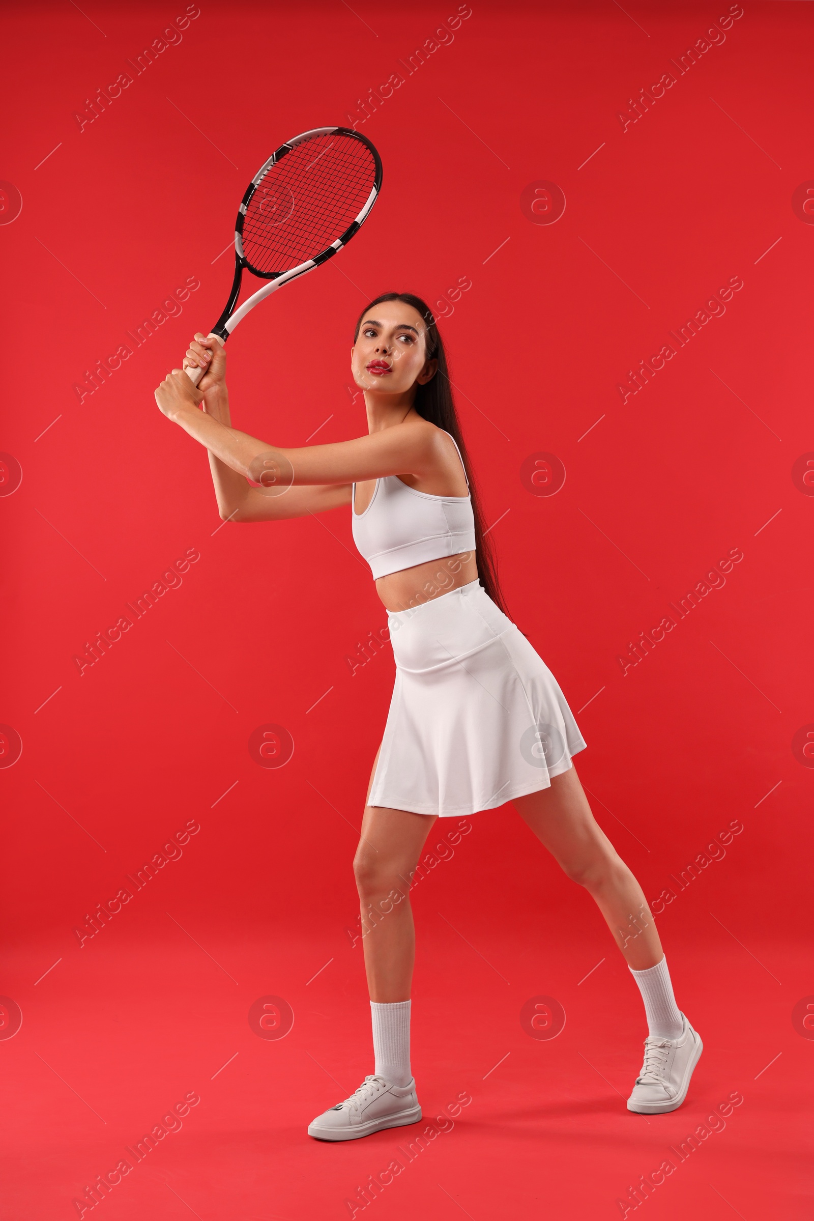 Photo of Tennis player with racket on red background