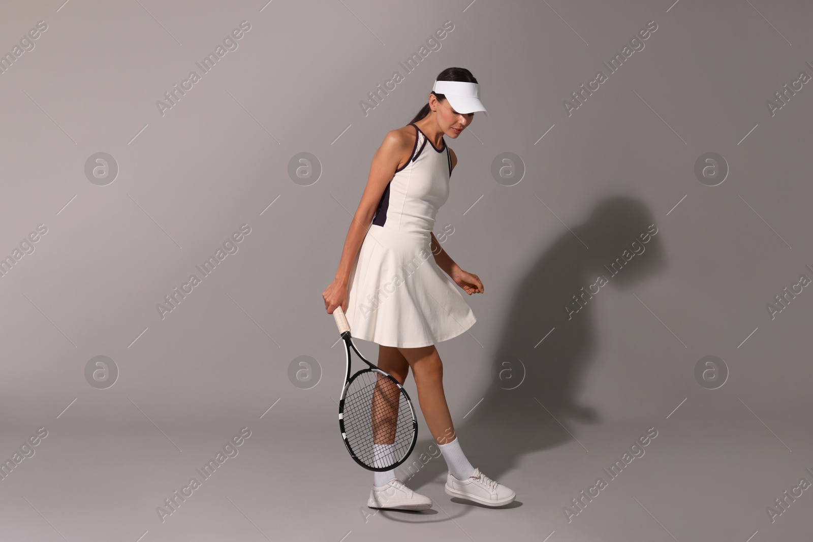 Photo of Tennis player with racket on grey background