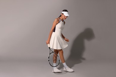 Tennis player with racket on grey background