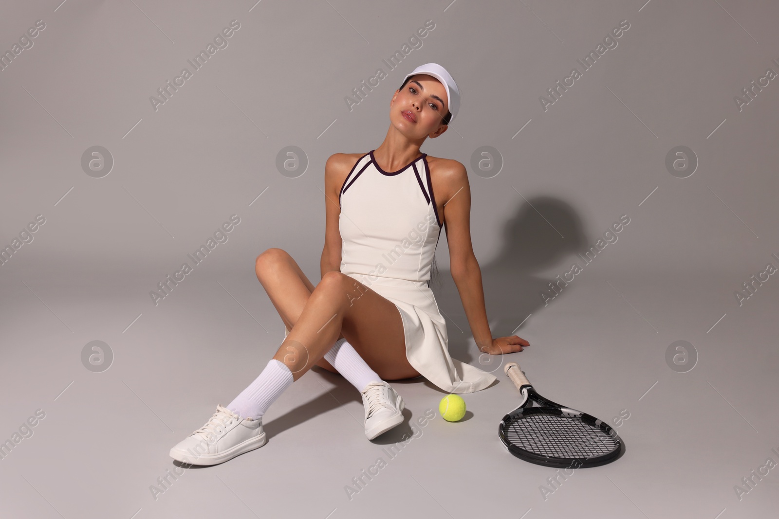 Photo of Tennis player with racket and ball on grey background