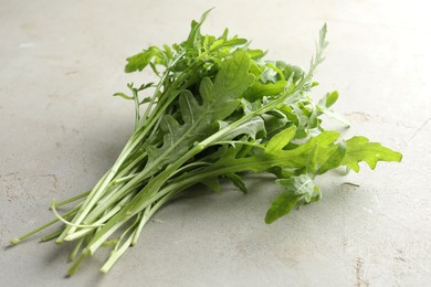 Photo of Many fresh arugula leaves on grey textured table, closeup