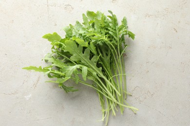 Photo of Many fresh arugula leaves on grey textured table, top view