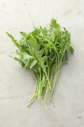 Photo of Many fresh arugula leaves on grey textured table, top view