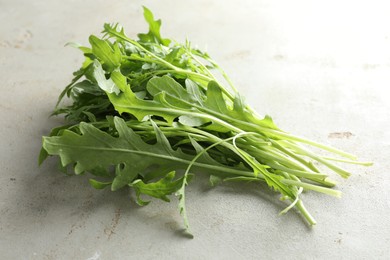 Photo of Many fresh arugula leaves on grey textured table