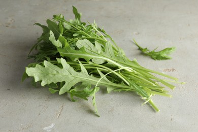 Photo of Many fresh arugula leaves on grey textured table