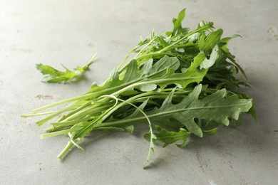 Photo of Many fresh arugula leaves on grey textured table