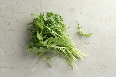 Photo of Many fresh arugula leaves on grey textured table, top view