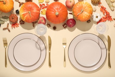 Photo of Beautiful table setting with autumn decor on beige background, flat lay