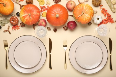 Photo of Beautiful table setting with autumn decor on beige background, flat lay