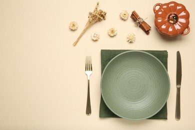 Beautiful table setting with autumn decor on beige background, flat lay. Space for text