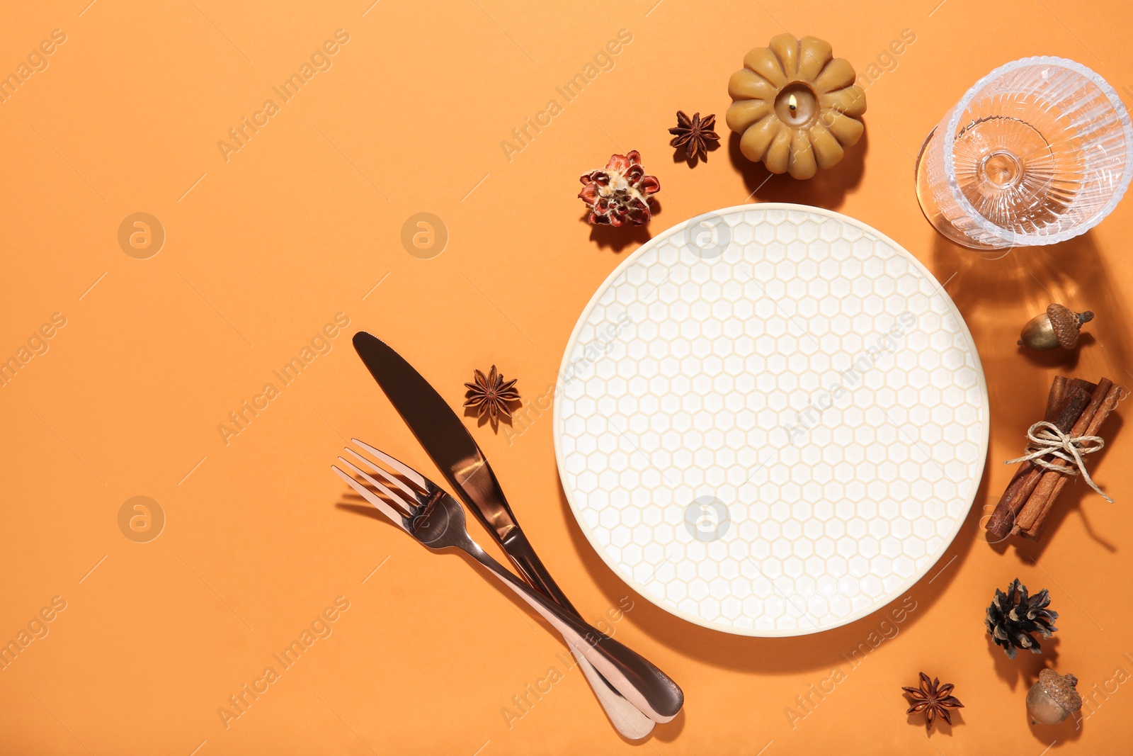 Photo of Beautiful table setting with autumn decor on orange background, flat lay