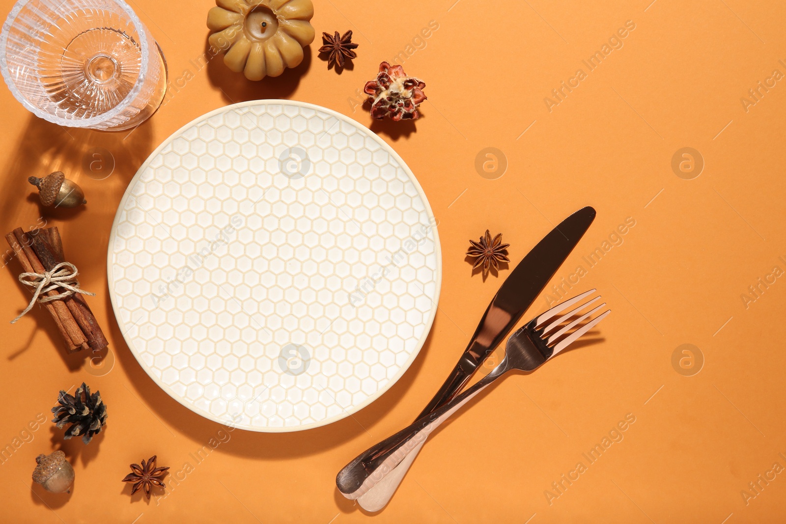 Photo of Beautiful table setting with autumn decor on orange background, flat lay