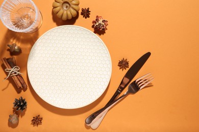 Beautiful table setting with autumn decor on orange background, flat lay