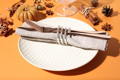 Photo of Beautiful table setting with autumn decor on orange background, closeup