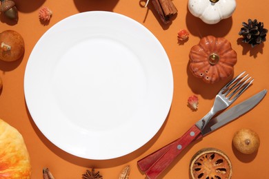 Photo of Beautiful table setting with autumn decor on orange background, flat lay