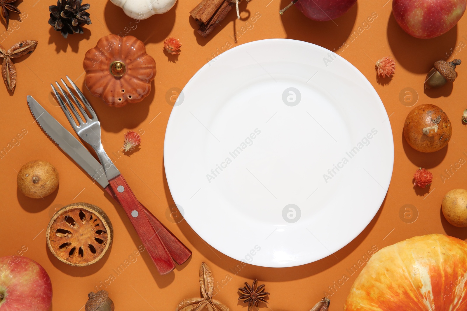 Photo of Beautiful table setting with autumn decor on orange background, flat lay