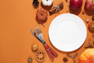 Photo of Beautiful table setting with autumn decor on orange background, flat lay