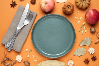 Photo of Beautiful table setting with autumn decor on orange background, flat lay