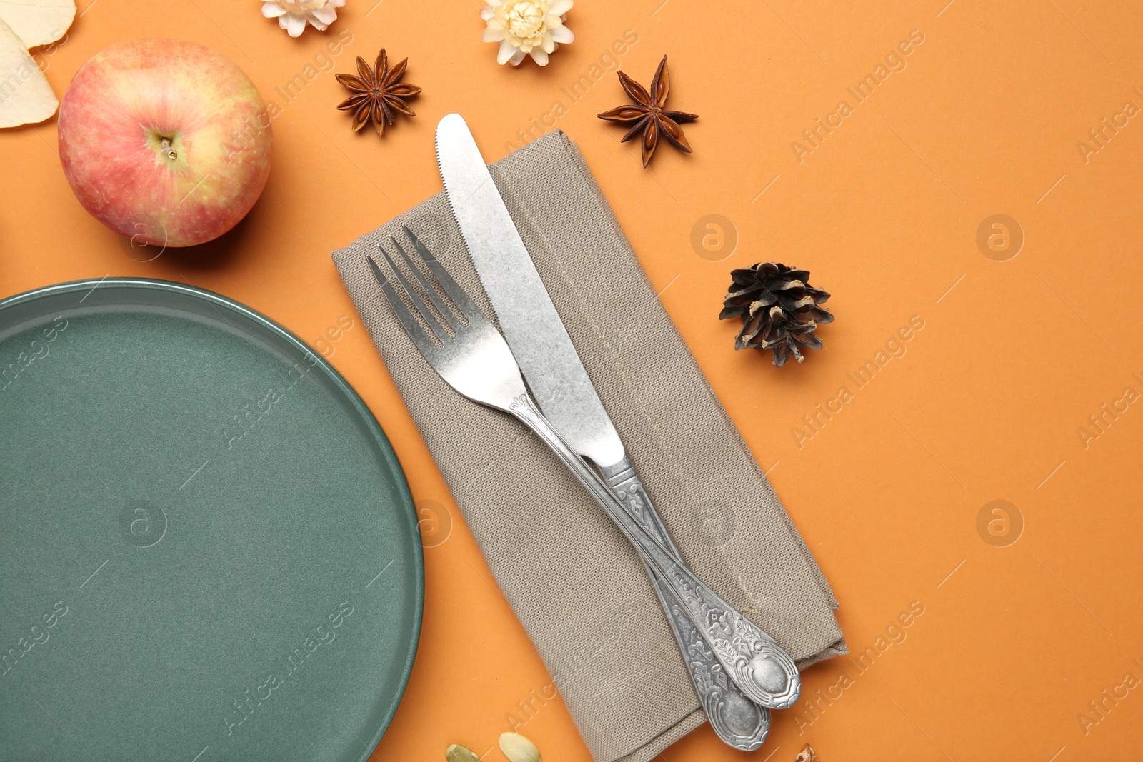 Photo of Beautiful table setting with autumn decor on orange background, flat lay