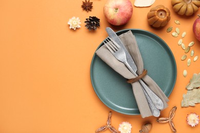 Photo of Beautiful table setting with autumn decor on orange background, flat lay. Space for text