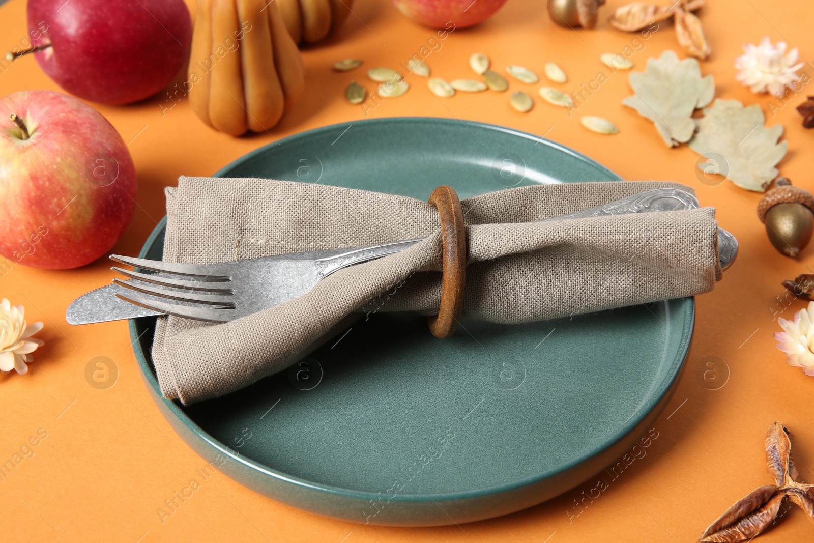 Photo of Beautiful table setting with autumn decor on orange background, closeup