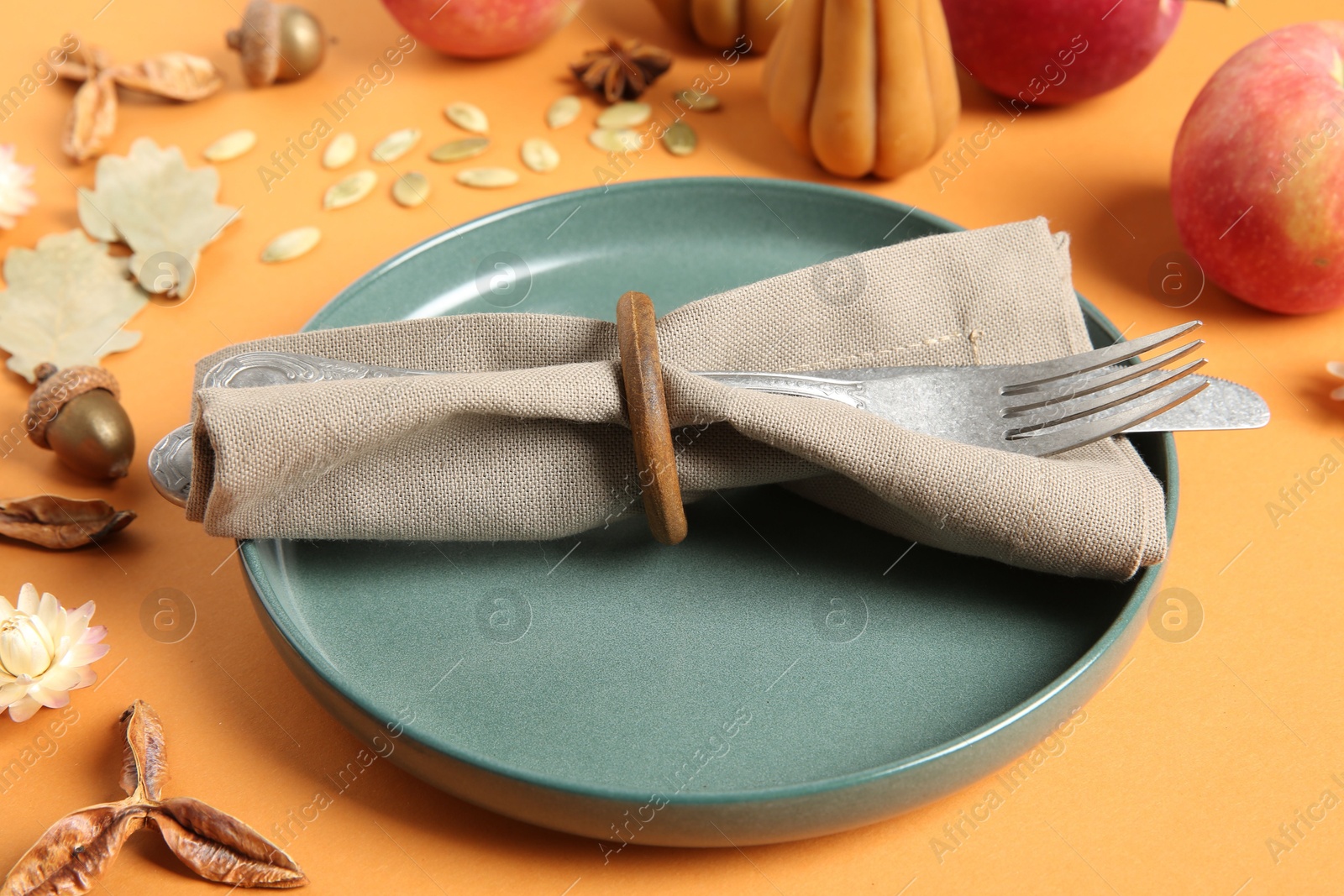 Photo of Beautiful table setting with autumn decor on orange background, closeup