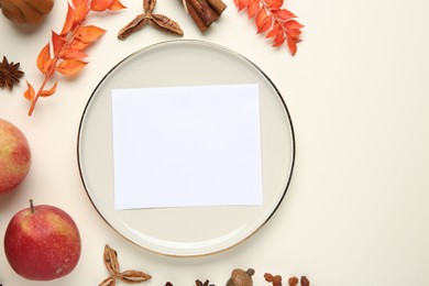 Stylish plate, blank card and autumn decor on white background, flat lay