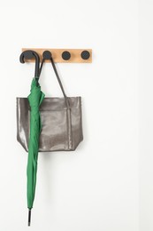 Photo of Green umbrella and bag on rack in hallway