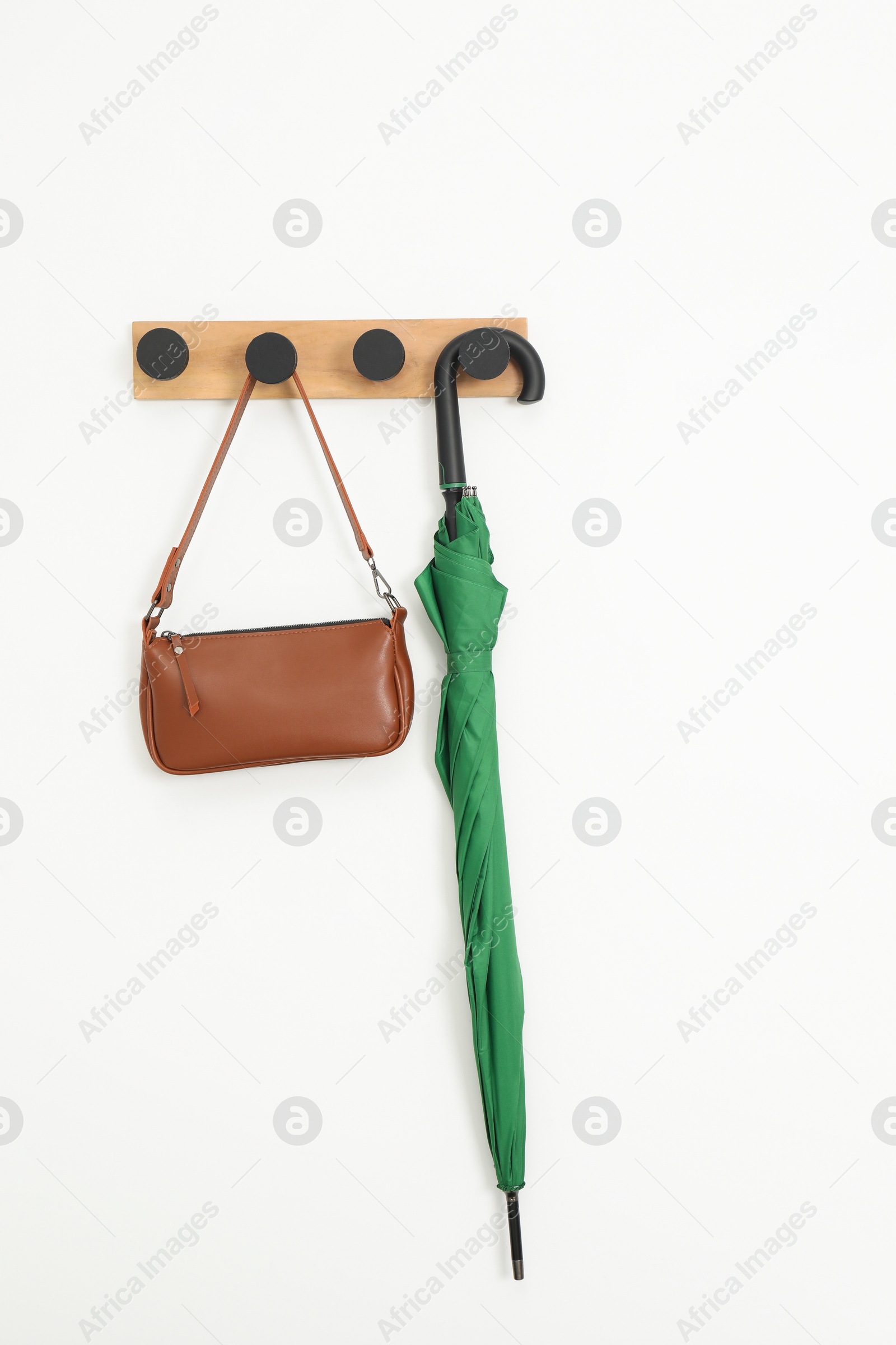 Photo of Green umbrella and bag on rack in hallway