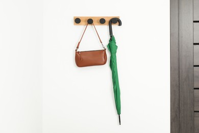 Photo of Green umbrella and bag on rack in hallway