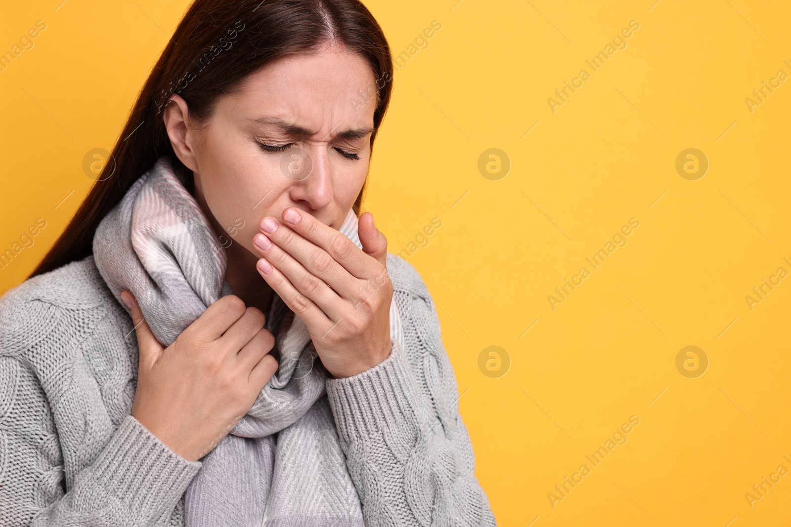 Photo of Sick woman suffering from cold symptoms on orange background, space for text