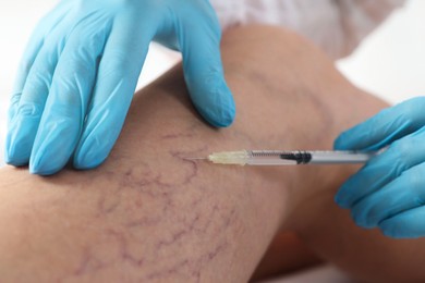 Photo of Varicose veins treatment. Doctor giving injection to patient indoors, closeup