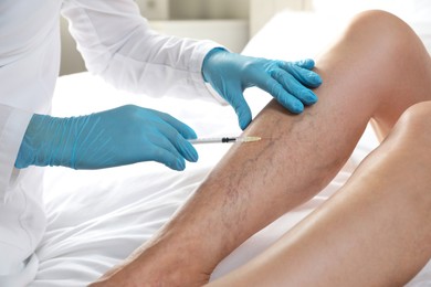 Varicose veins treatment. Doctor giving injection to patient indoors, closeup