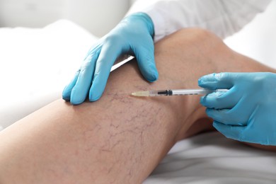 Varicose veins treatment. Doctor giving injection to patient indoors, closeup