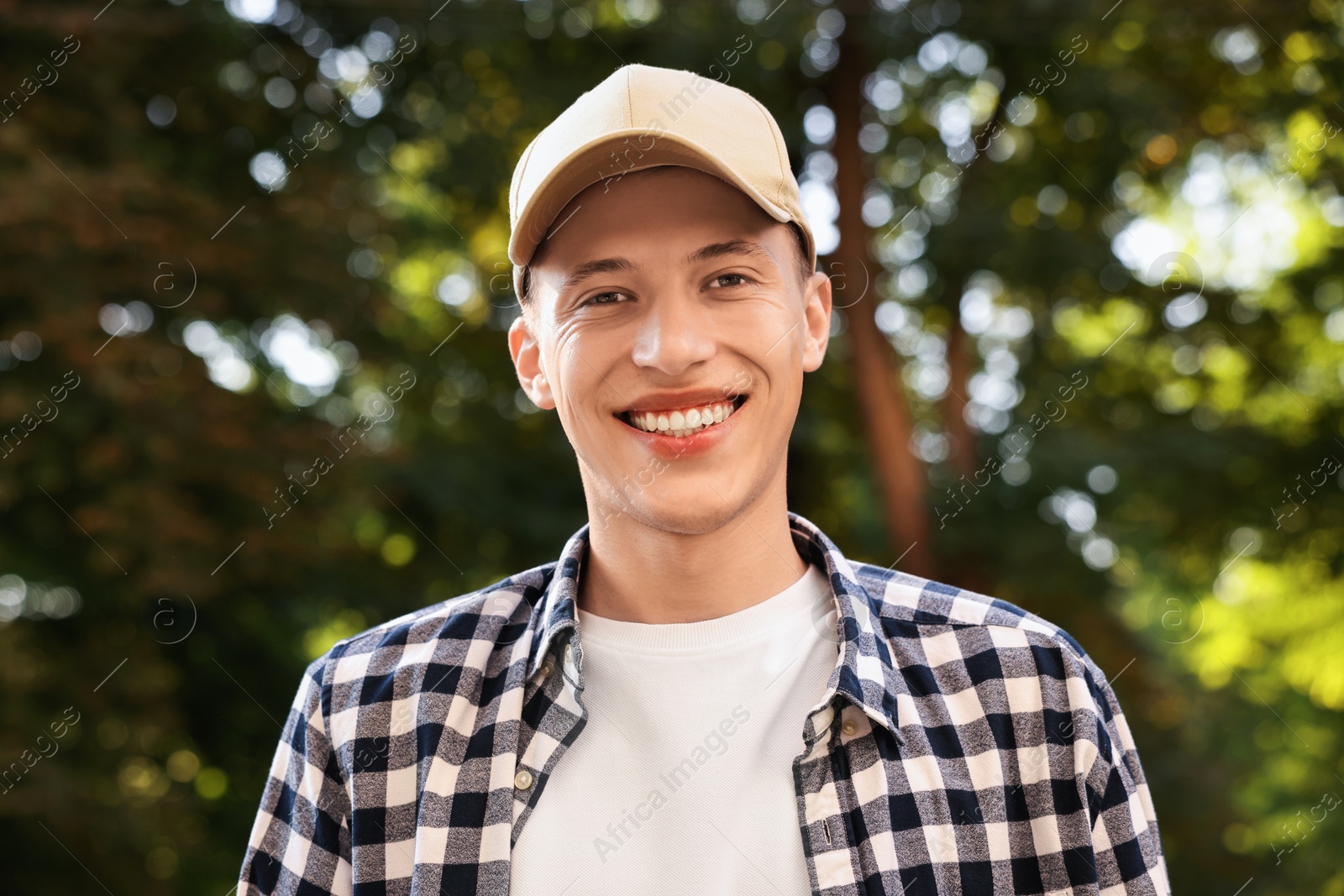 Photo of Portrait of smiling man in baseball cap outdoors