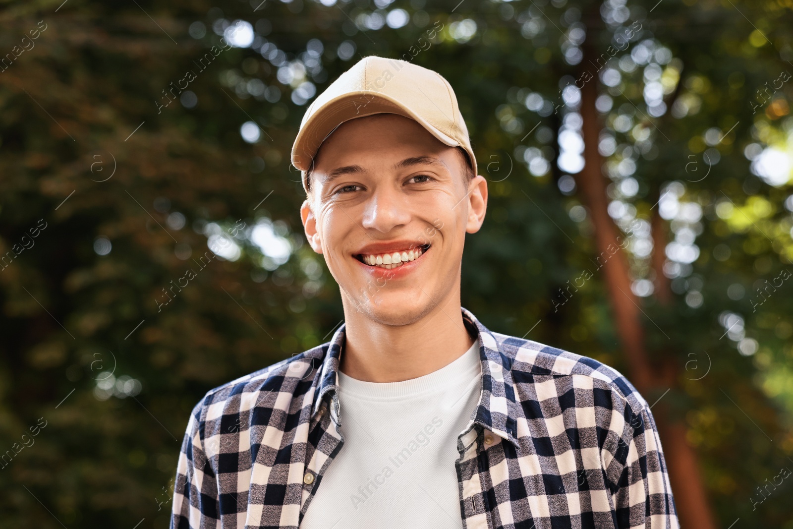 Photo of Portrait of smiling man in baseball cap outdoors