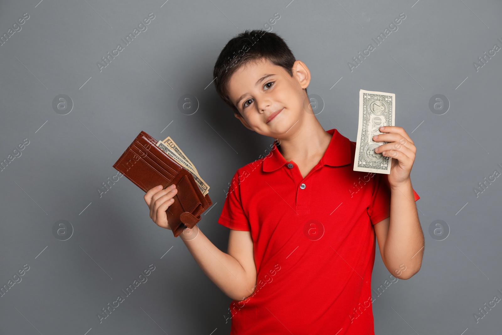 Photo of Cute boy with wallet and pocket money on grey background