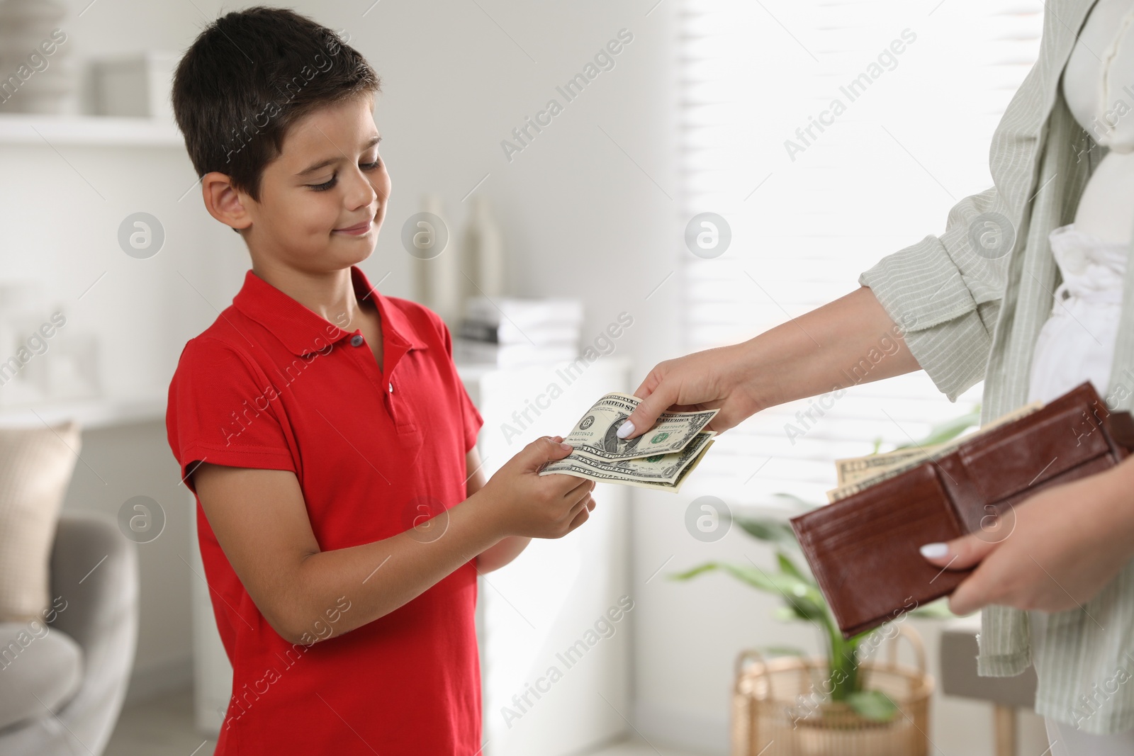 Photo of Mother giving pocket money to her son at home