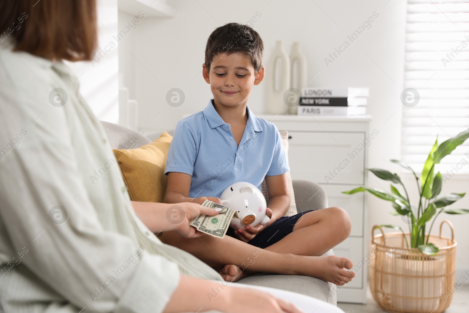 Photo of Mother giving pocket money to her son at home