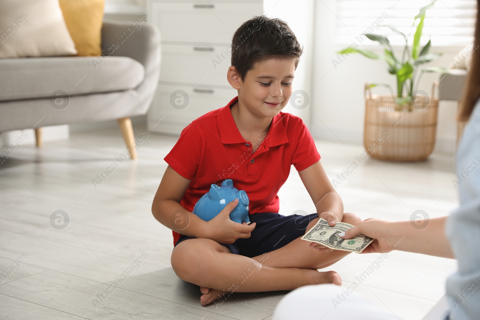 Photo of Mother giving pocket money to her son at home